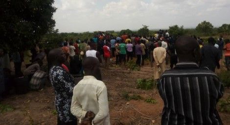 Individuals gathered at mass burial in the Gona Rogo community