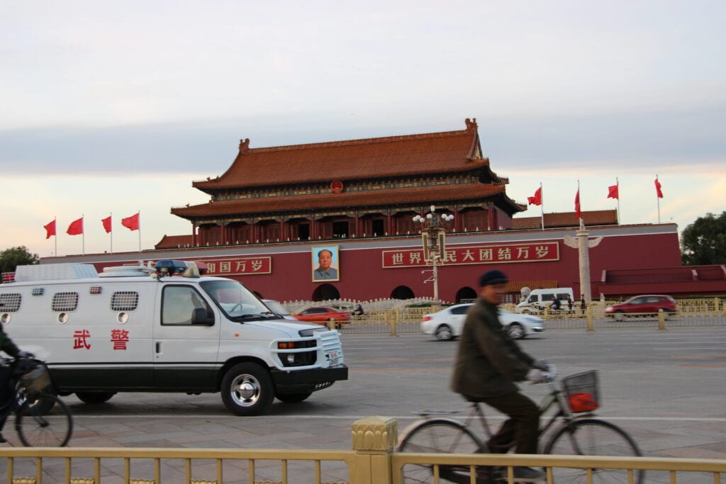 Police van and cyclist in Beijing, China
