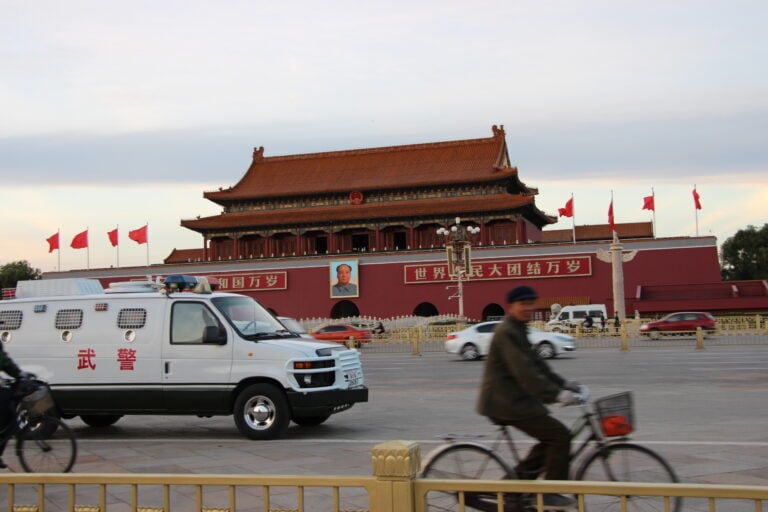 Police van and cyclist in Beijing, China