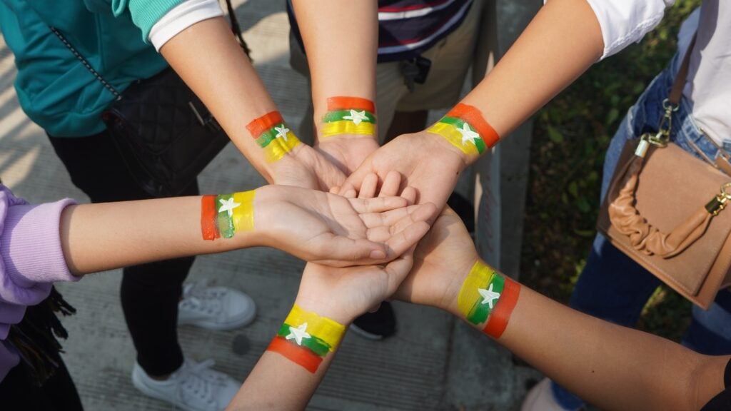 Protesters with Myanmar/Burma flag painted on their wrists.