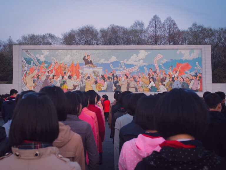 Women in front of a mural in North Korea.