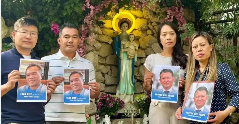VNM Friends and family hold photos of Tran Hiep and Nguyen Duc Thuan
